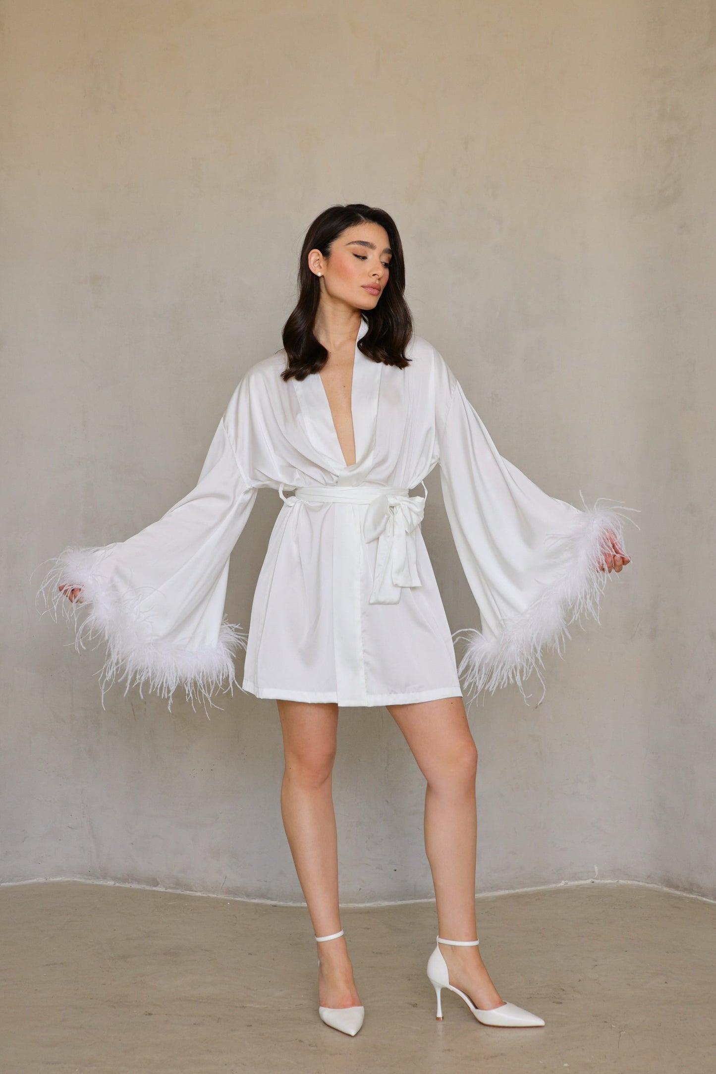 Model wearing Swan robe -full front view, sleeves spread to show dramatic feather cuffs.