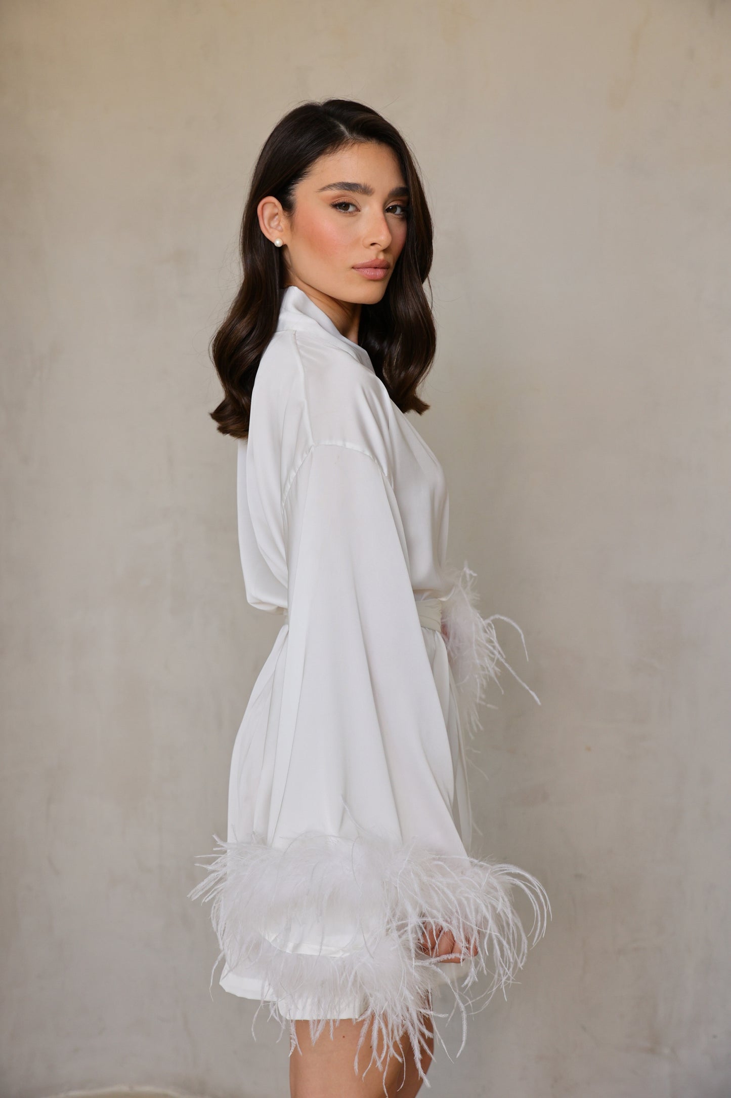 Swan robe side profile highlighting soft drape, tie-belt and feather-trimmed cuffs.