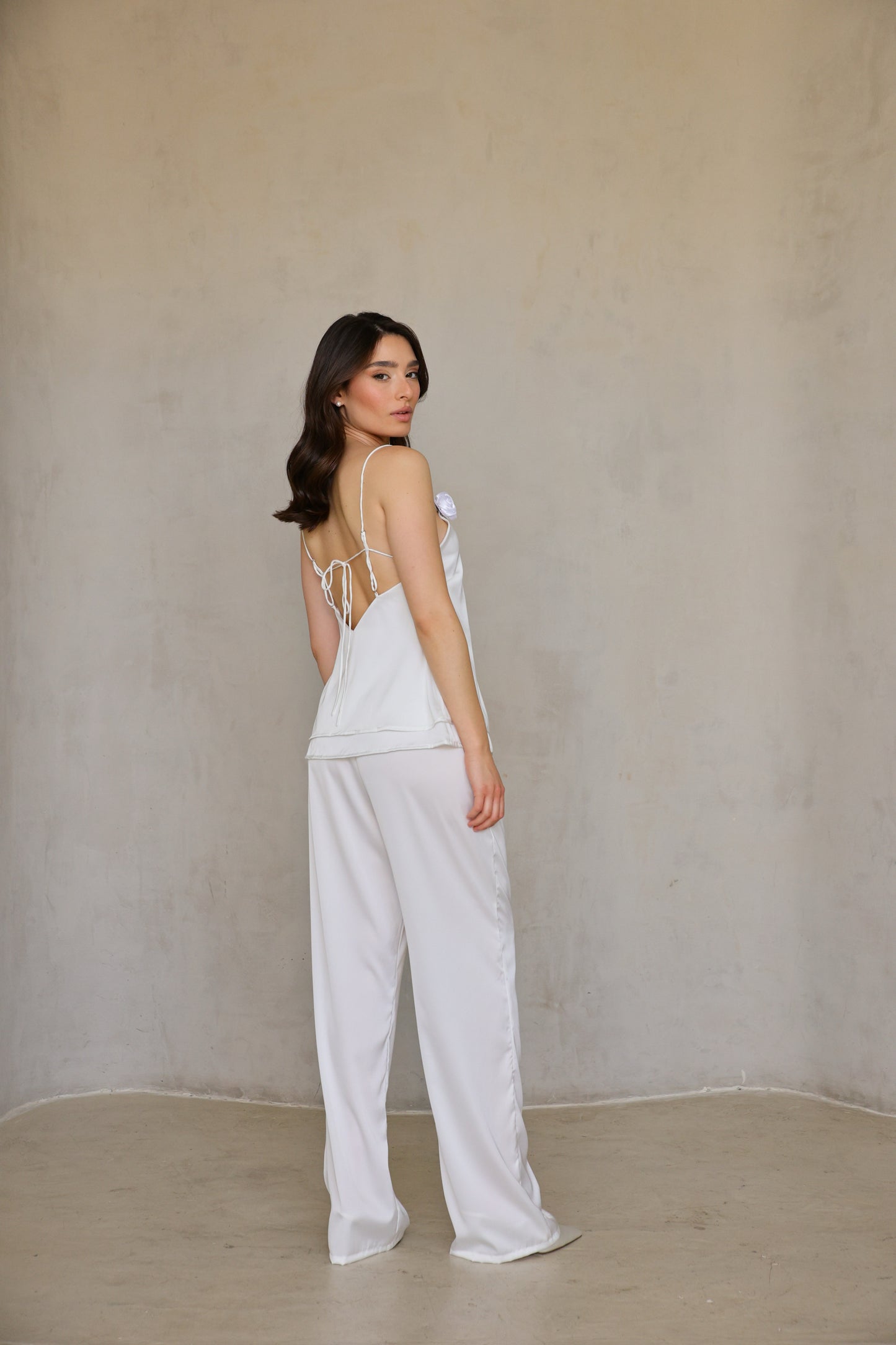 Back three-quarter view of Ivory Rose satin pants highlighting fit and flow