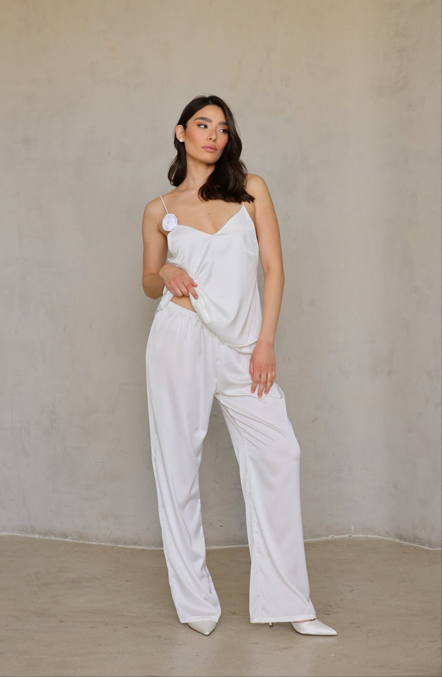 Model wearing Ivory Rose satin pants, full front view in relaxed bridal-lounge pose