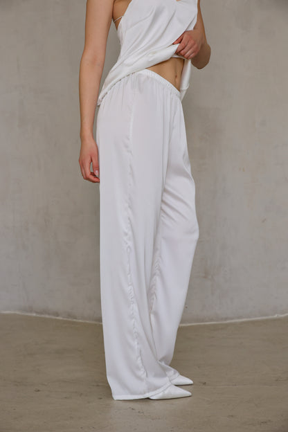 Ivory Rose satin pants side detail showing soft drape and ankle length, three-quarter view